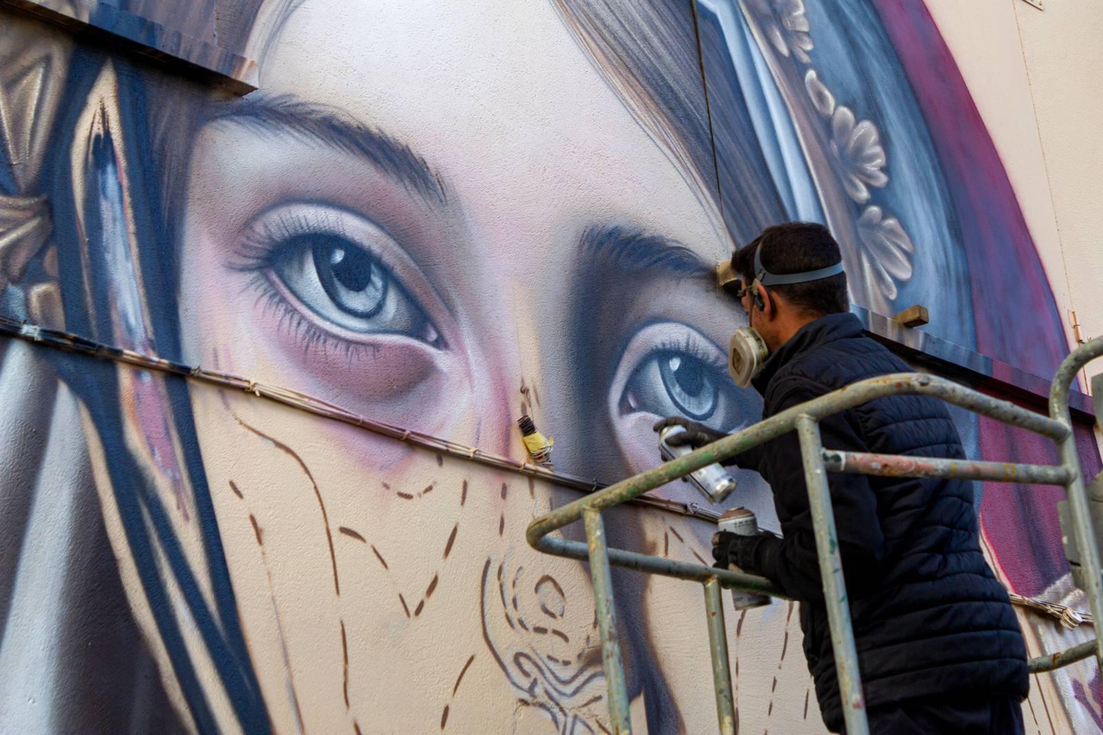 Artista trabajando en el mural